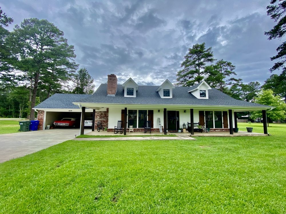 Completed shingle roof by Presley Roofing on a white farmhouse-style home