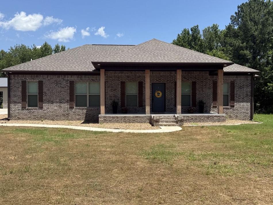 Completed residential shingle roof by Presley Roofing on a gray brick home in Central Arkansas