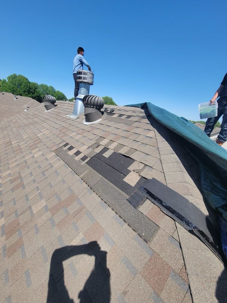 Presley Roofing crew performing a roof repair, removing damaged shingles