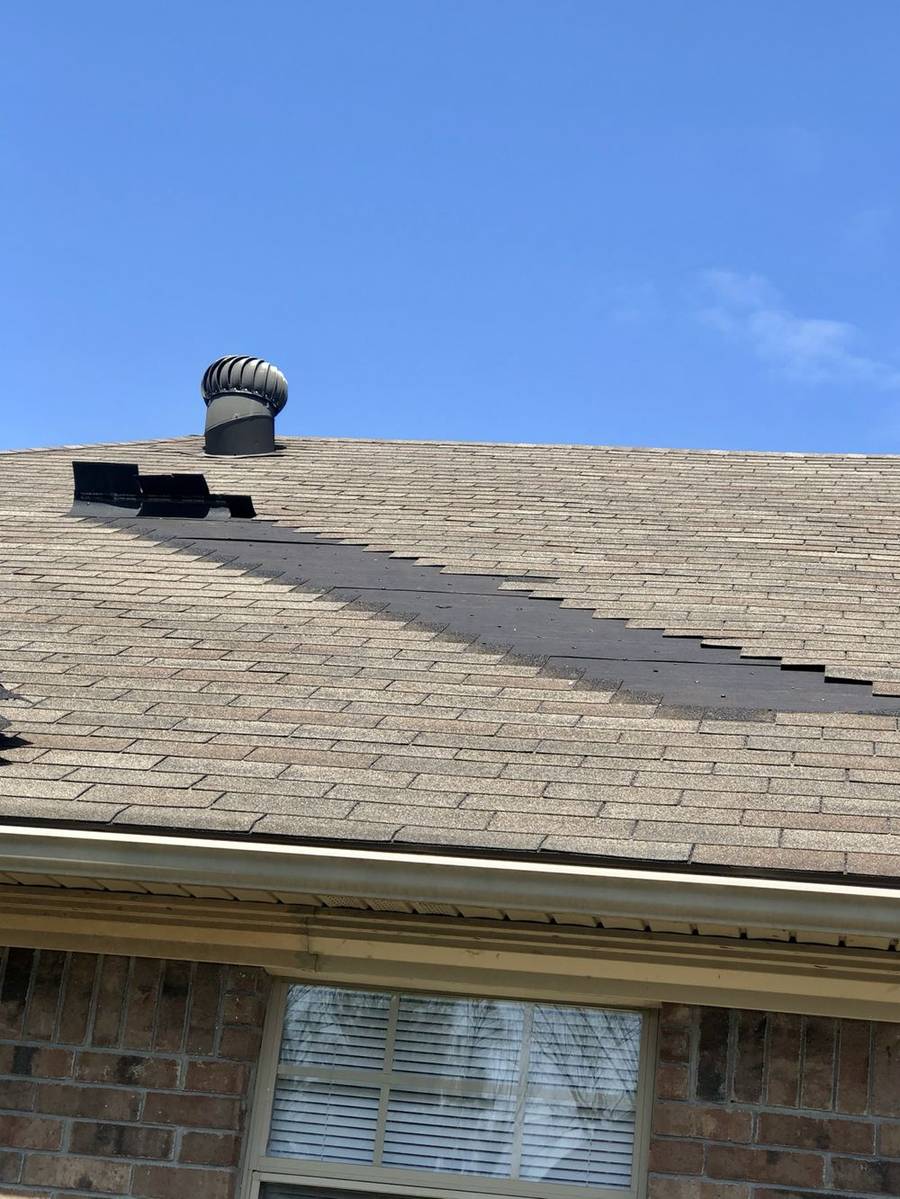 Wind and storm damage exposed on a shingle roof during a Presley Roofing inspection